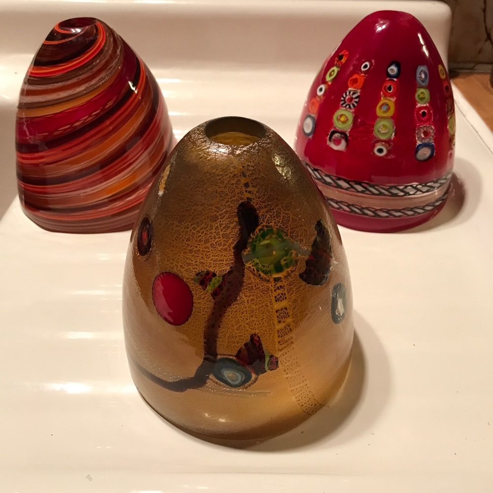 Three glass artistic pendant light shades.